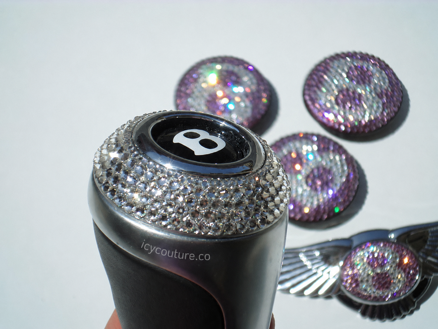 Custom crystal Bentley gear shift knob by ICY Couture with Diamond Clear Swarovski Crystals and matching iridescent crystal car emblems for luxury car interior customization.