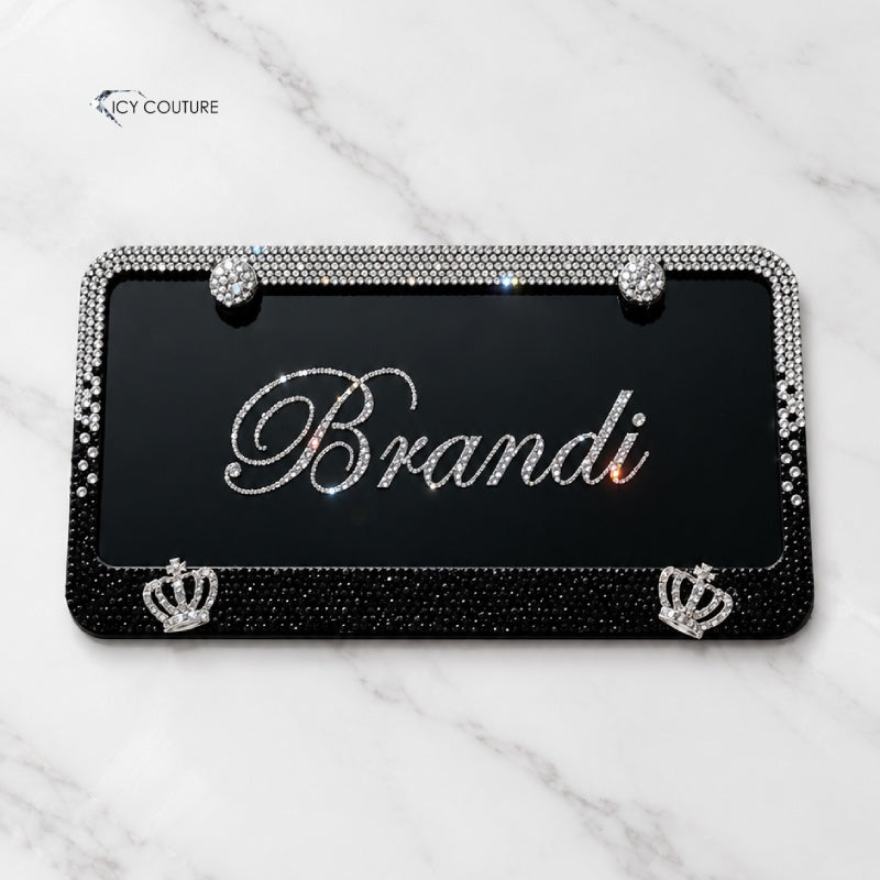 Personalized black license plate with the name Brandi in Clear crystals, matching crystal frame crystallized in Black Diamond Ombre, bling screw caps and crown details by ICY Couture, a custom luxury car gift.